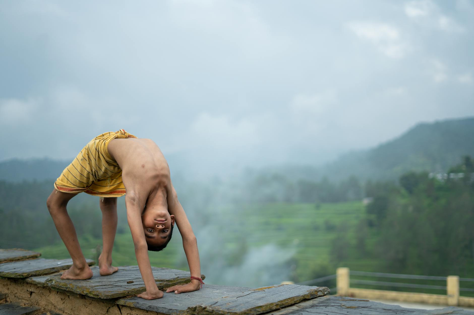 A child laughing while balancing on one leg during a yoga class.