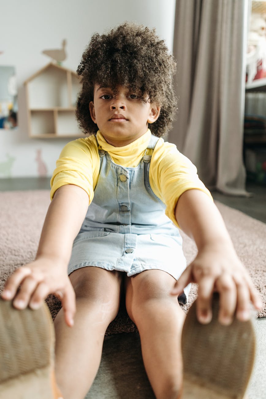 Happy children doing playful yoga poses in a bright room.
